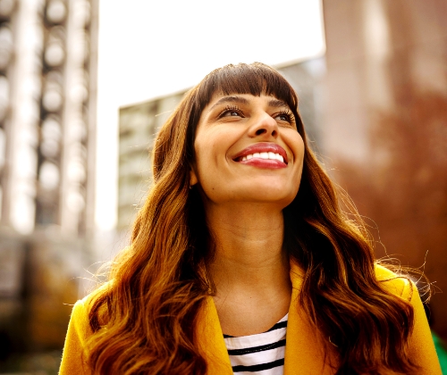 Young woman, smiling, with the city in the background