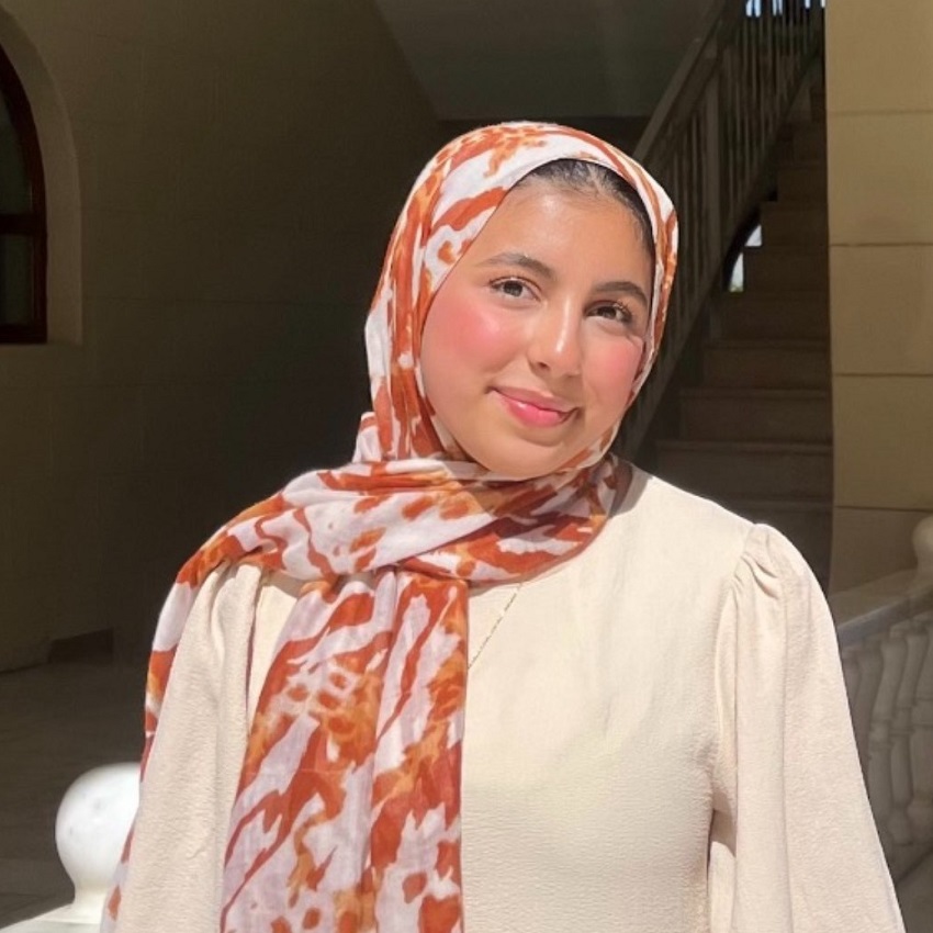 2024 recipient, Maryam Al-Sabawi, smiles, wearing a cream jacket and multi-coloured head scarf.