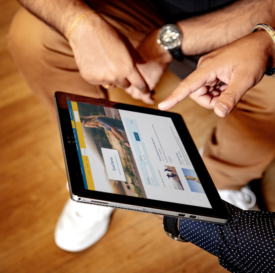 Close up of someone’s hands holding an iPad and pointing to the screen. The screen displays the Meridian website. 