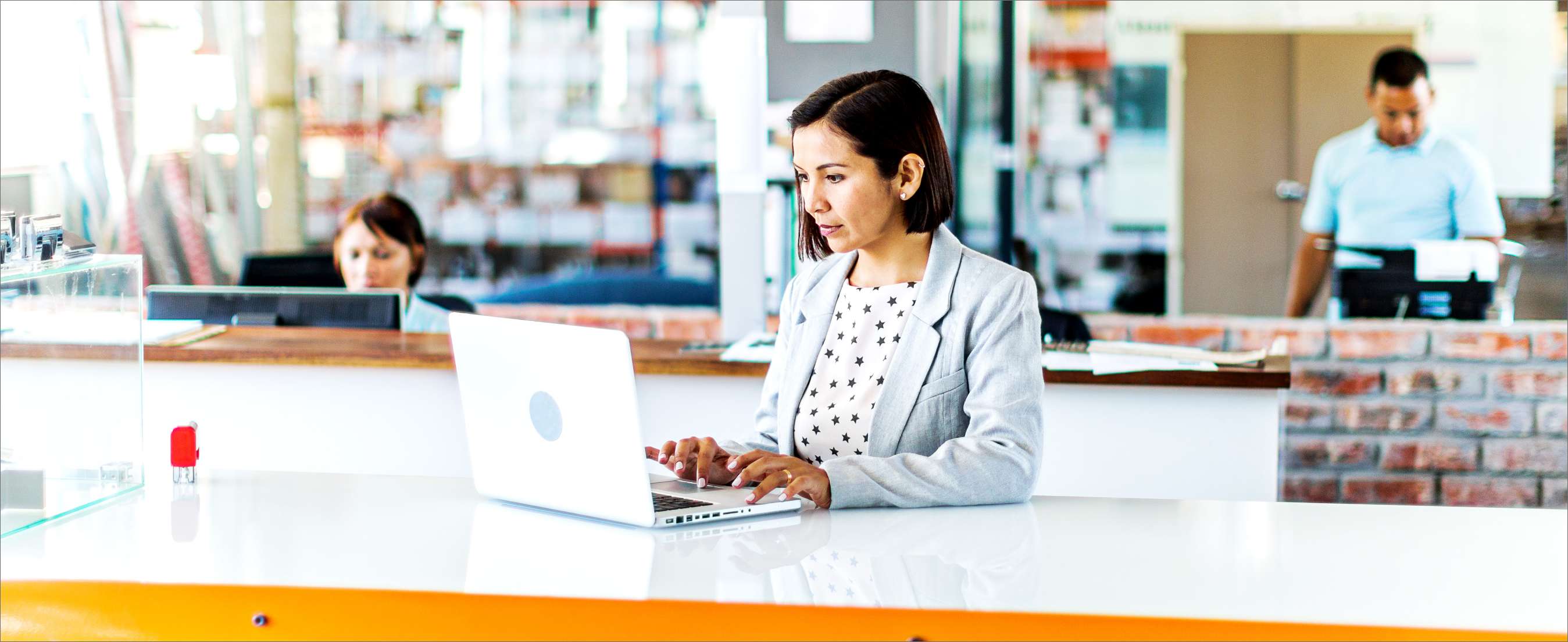 Female business woman in open plan office of a small business.