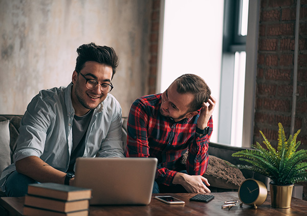 smiling couple looking at laptop